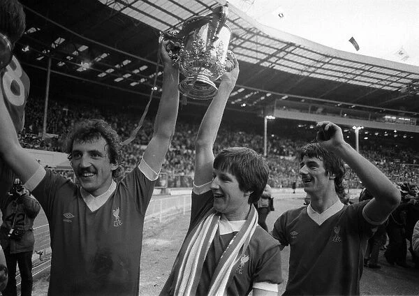 Liverpool footballers Alan Kennedy and Ronnie Whelan hold the League Cup trophy aloft at