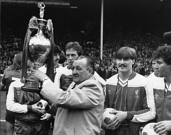 Liverpool manager proudly padres the League Championship trophy to the Liverpool