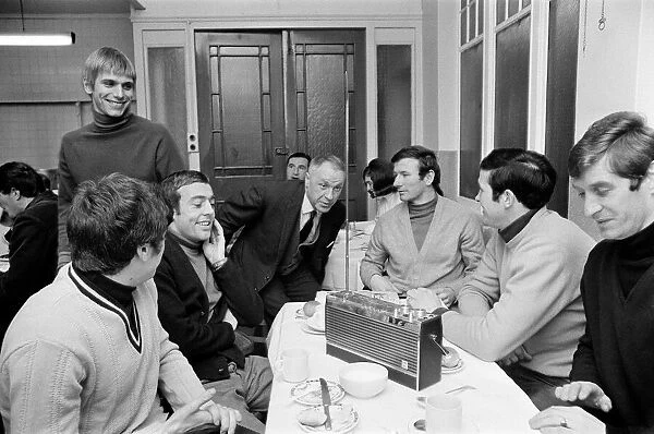 Liverpool manager Bill Shankly listening to the FA Cup draw with some of his players over