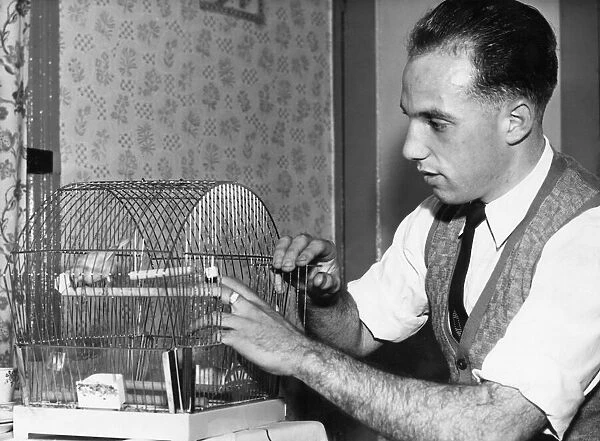 Liverpool full back Ronnie Moran with Joey, his pet canary at home. 26th October 1955