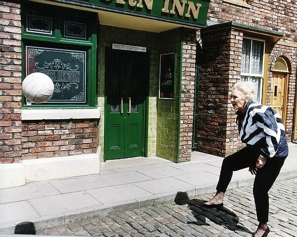 Liz Dawn Actress plays Vera in Coronation Street as she practices for a charity football