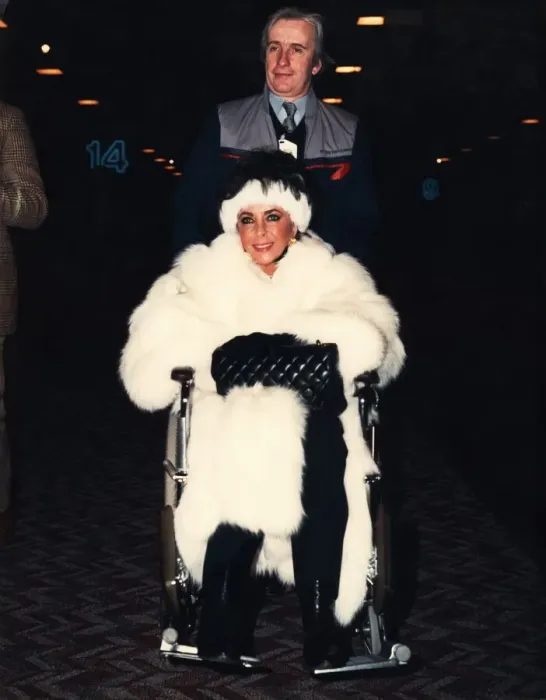 Framed Print : Liz Taylor is pushed through Heathrow airport ijn a wheelchair Framed Print : Liz Taylor is pushed through Heathrow airport ijn a wheelchair