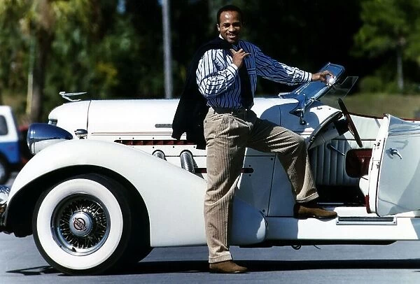 Lloyd Honeygham Boxer stands by a white classic car