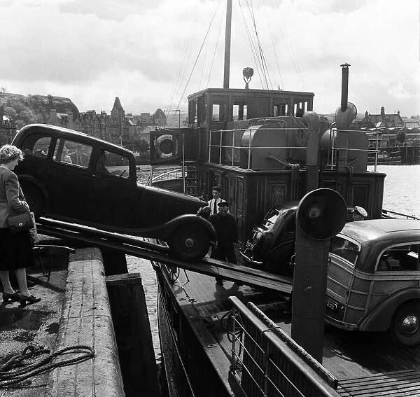 Loading a car onto a ferry steamer at the Quay at Oban. Oban is a resort town within