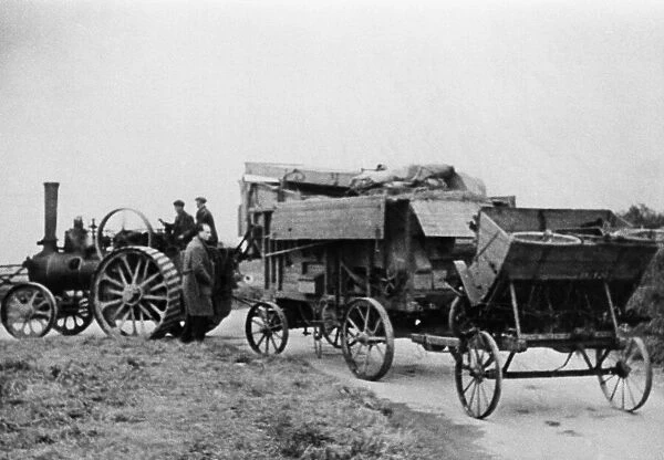 Local farmer with his steam tractor engine and threshing machine seen here leaving