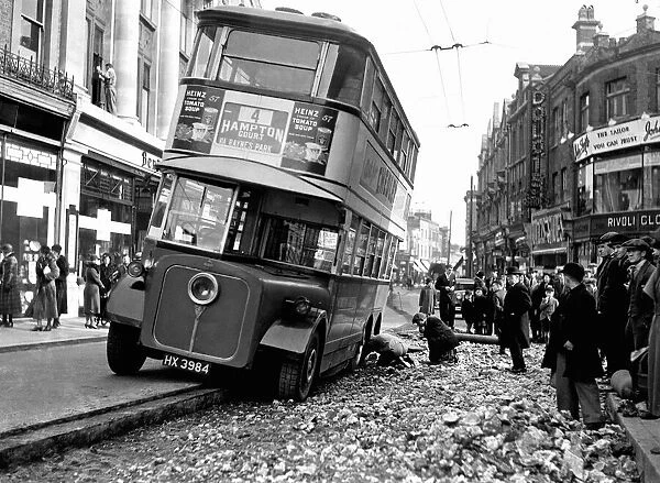 London Bus having puncture repaired on a busy street. 9th March 1933
