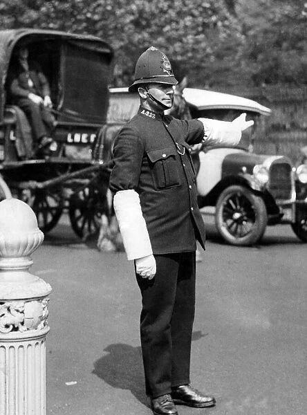 A London policeman on traffic duty with heavy bulk helmet, tunic