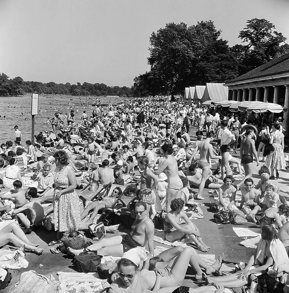 Londons Hyde Park Lido. A crowd a of sunbathers by the Serpentine