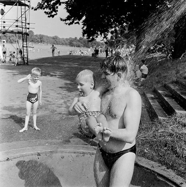 Londons Hyde Park Lido. A father and young son having a shower at the Serpentine