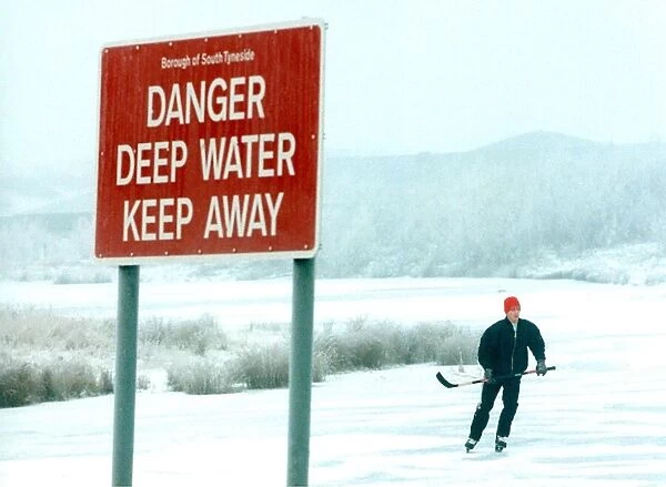 A lone figure skater ignores a prominent sign to skate on a frozen lake in West Boldon in