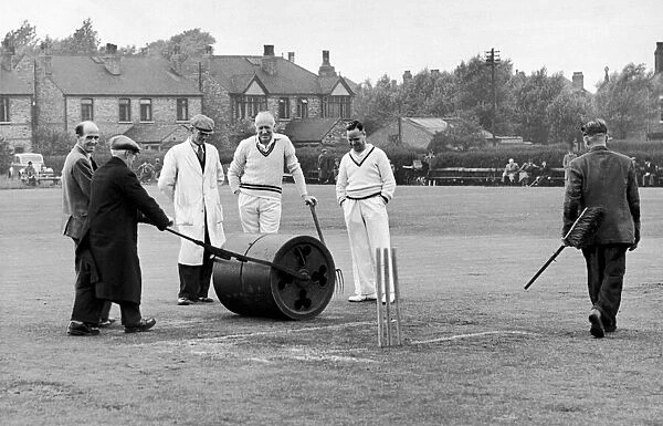 Longsight Cricket Club, Lancashire. Ground staff prepare the wicket while players