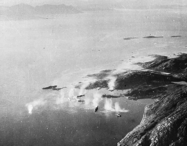 Looking down on Lodingen Harbour, Norway as (left) a tanker receives a direct hit