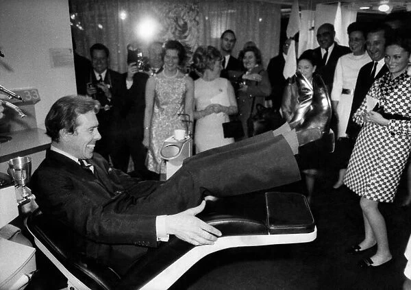 Lord Snowdon trying out the motorised reclining dentist chair at the exibition