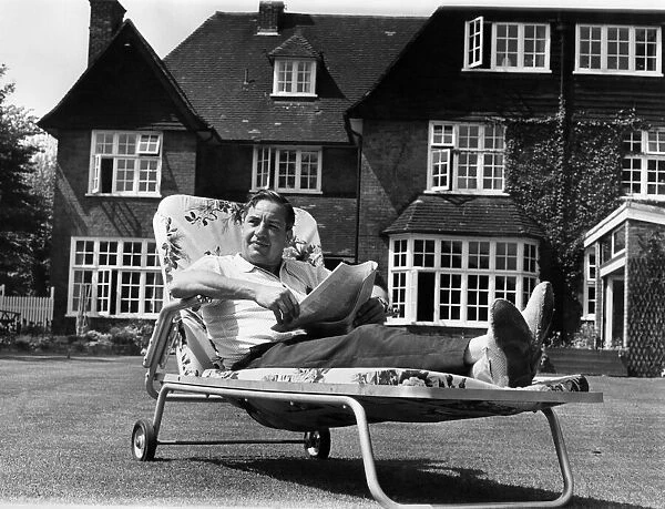 Lord Willis was wearing a red check summer shirt, reclining in a garden chair on a lush