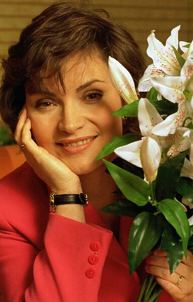 Lorraine Kelly TV presenter sitting next to green white plant