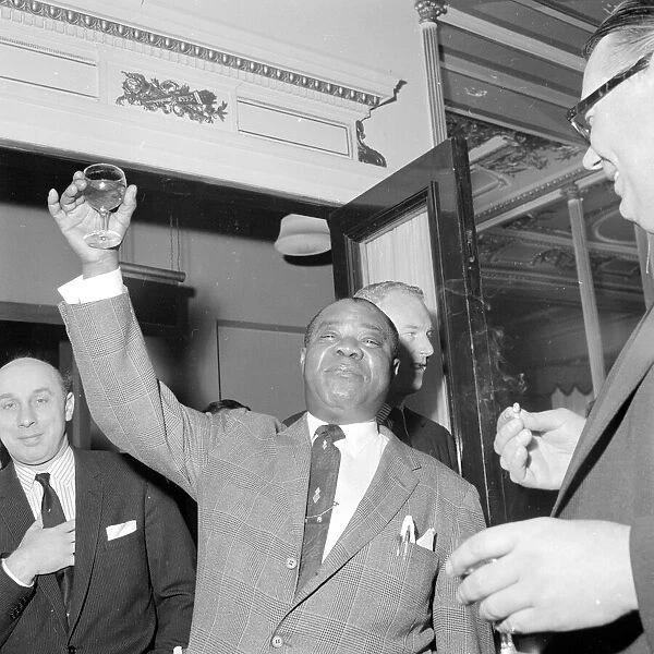 Louis Armstrong raises a glass during the Daily Mirror lunch to him at the Cafe Royal