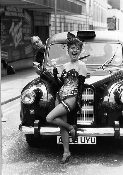 Lulu singer standing in front of a London taxi dressed in a skimpy basque