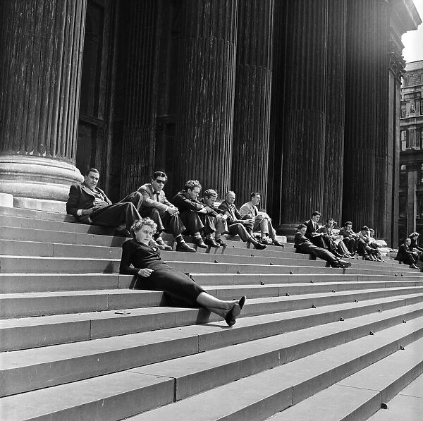 Lunch hour sunbathers sit on the steps of St Pauls Cathedral, London. 1st June 1954