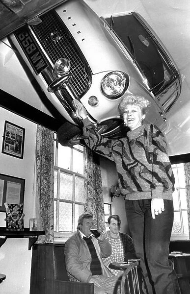 Lynne Stevens, assistant manager, polishes the 1962 Ford Consul in the lounge of