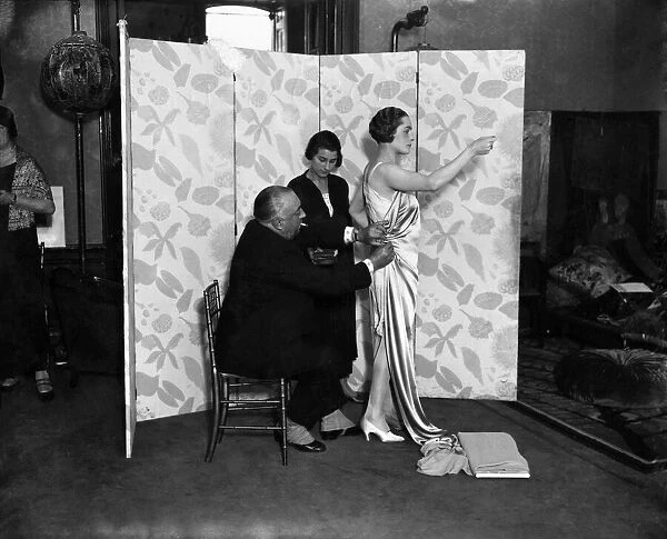 M. Paul Poiret designing a gown on one of his mannequins. December 1924 P008637