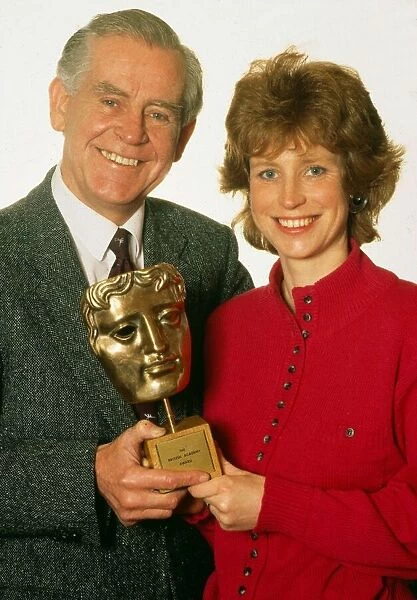 Magnus Magnusson with daughter Sally, holding a BAFTA award. March 1990