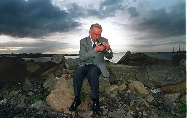 Magnus Magnusson television presenter, back in Orkney. Seen here thinking over