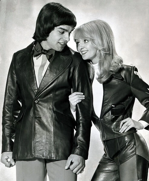 Male and female model linking arms and looking at each other both wearing leather jackets