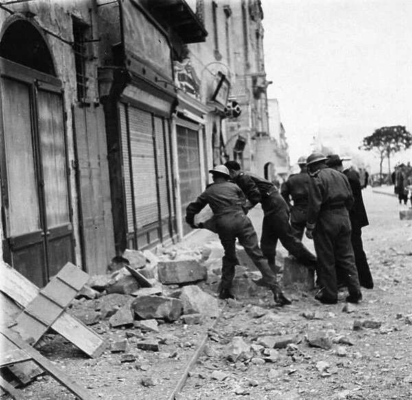 Maltese police helping to clear debris after an air raid. March 1942