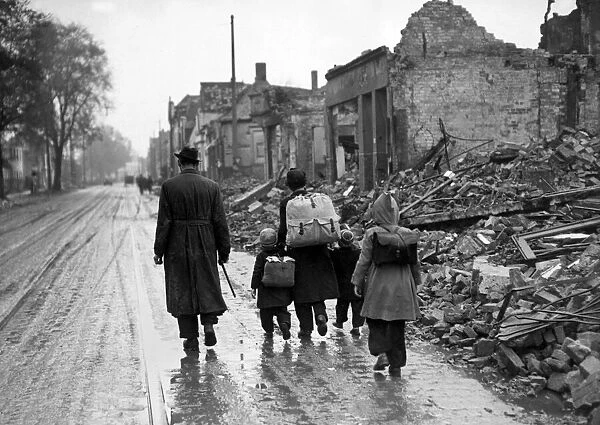 A man with his children walking the streets through a ruined French town during