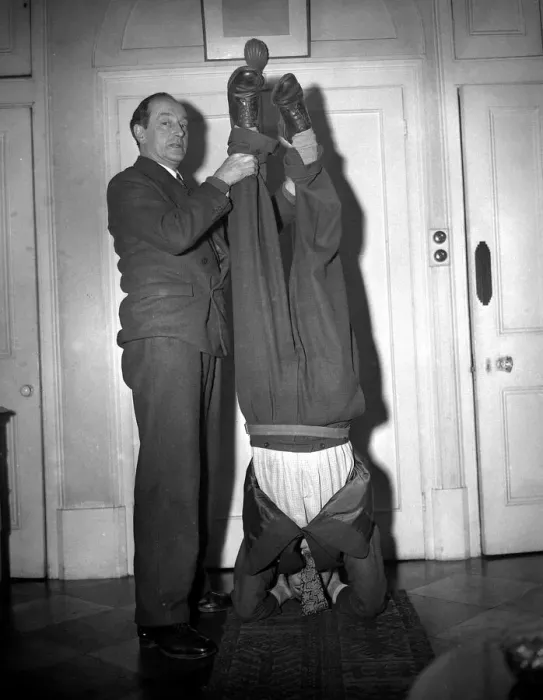 Framed Print : Man does a head stand while other man holds his feet Framed Print : Man does a head stand while other man holds his feet