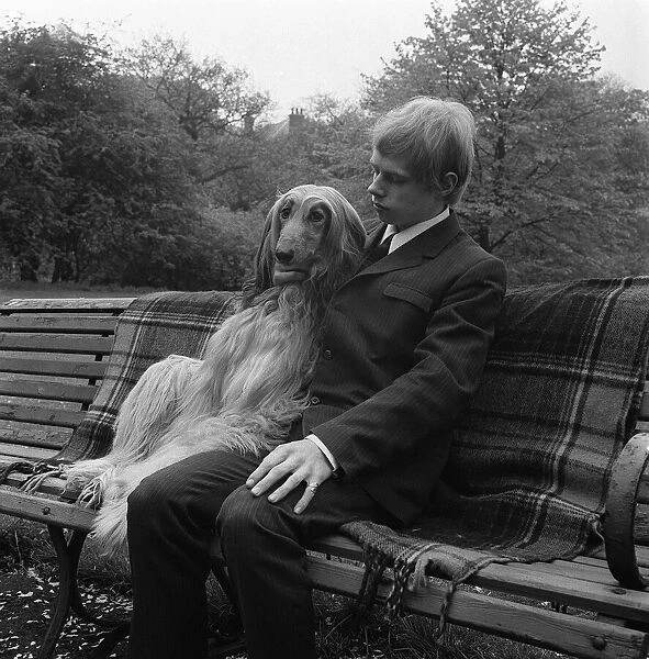 Man and dog sitting on park bench circa 1970