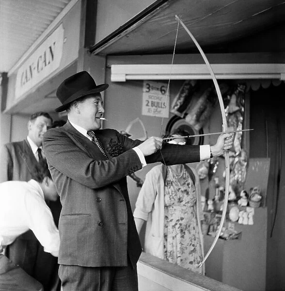 Man firing arrow on a fun fair side show. Agust 1952 C2976-003