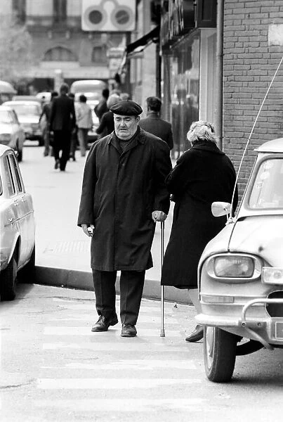 A man in a French town walking down the street April 1975 75-2078-013