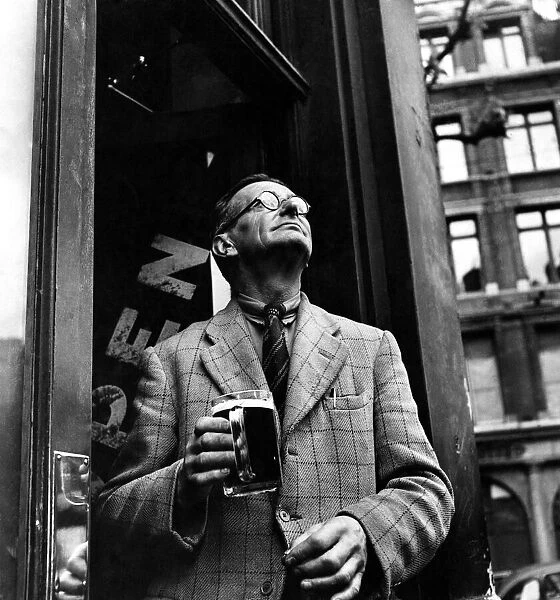 A man holding a tankard of beer in a pub doorway in Holborn. 1946 P009217