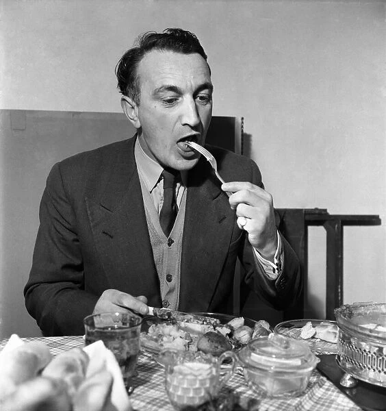 Man at home eating dinner at the table. November 1952 C5808-002