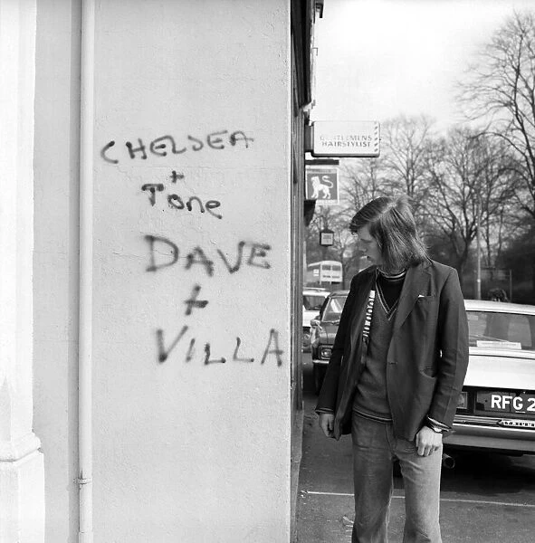 Man looking at a Graffiti covered wall after a football match February 1975