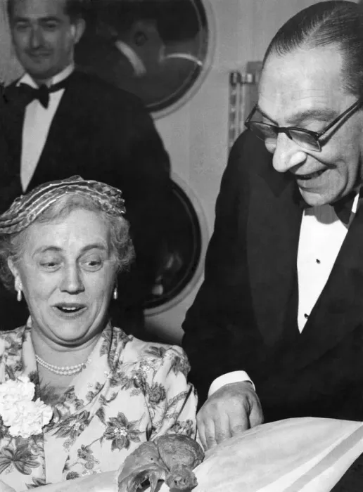 Framed Print : Man showing off a chicken drumstick to a woman at a dinner party Circa 1955