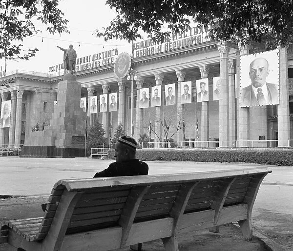 A man sits on a public bench in a deserted square in the Soviet city of Tashkent