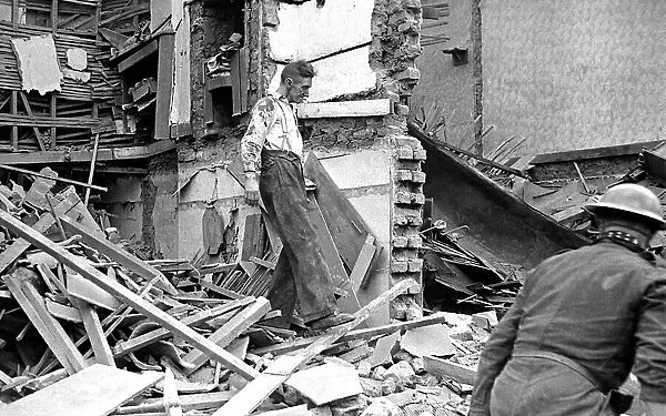 A man wades through the debris of bomb damage in Kings Cross after air raids