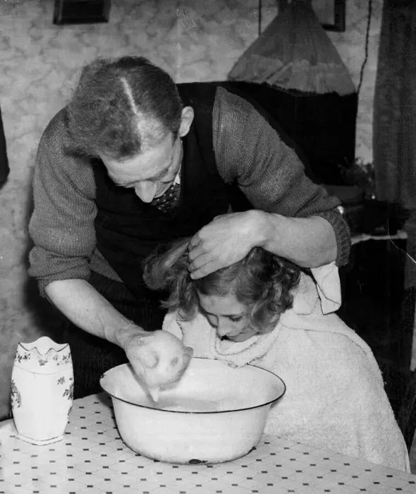 Framed Print : A man washing his daughters hair and face using soapy water in a bowl in their Framed Print : A man washing his daughters hair and face using soapy water in a bowl in their