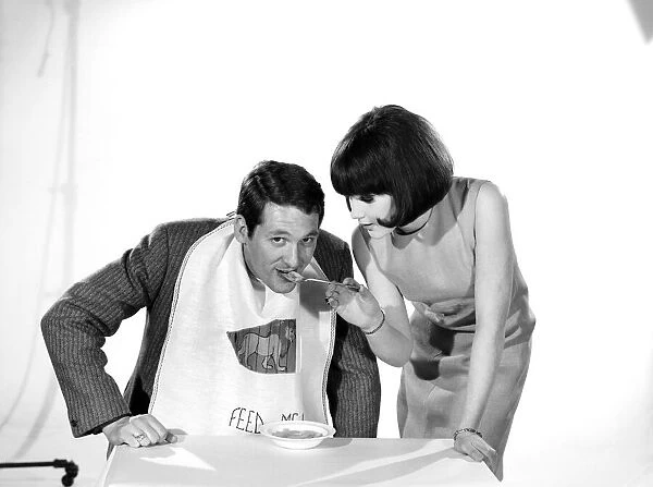 Man wearing feed me bib being fed by woman. Models: Michael Lester and Debbie Attwood