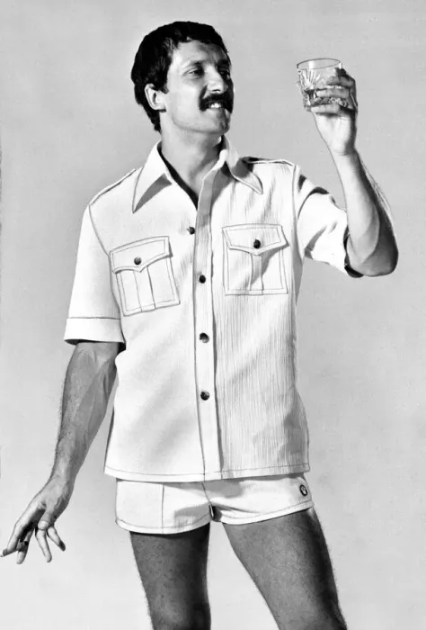Framed Print : A man wearing a shirt with shorts looking at a glass of whisky Framed Print : A man wearing a shirt with shorts looking at a glass of whisky
