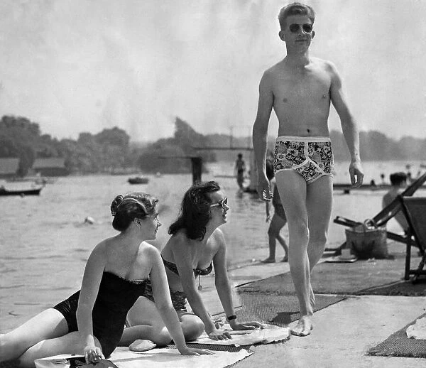 A man wearing Y fronts walking past two girls looking at him. July 1952