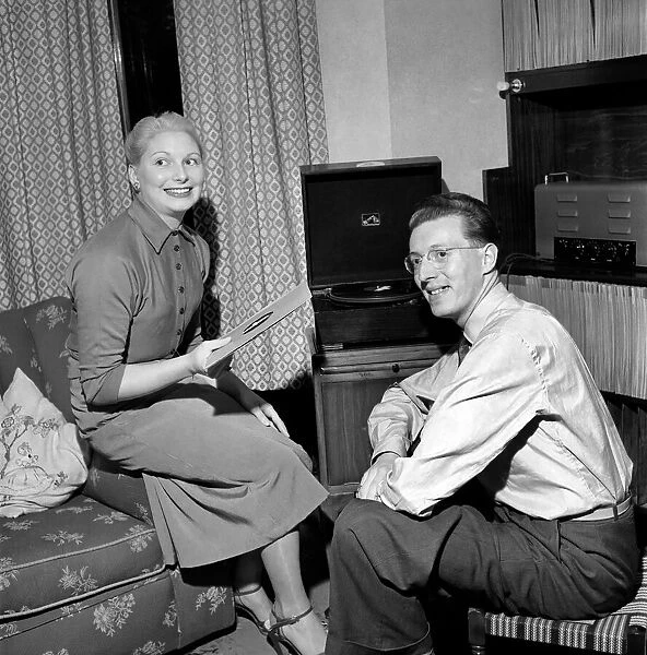 Man and wife sit and listen to music on their record player. September 1953 D5574
