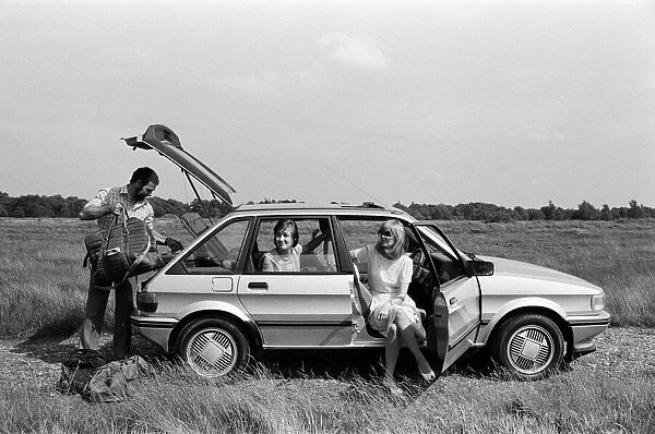 A man, woman and girl in a MG Maestro. 8th June 1983