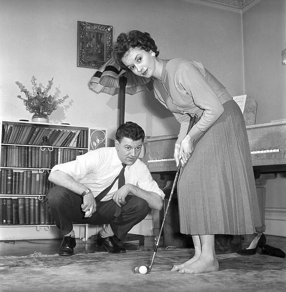 Man, Woman, Golf: Husband tries to teach his wife to putt. March 1950 A217b