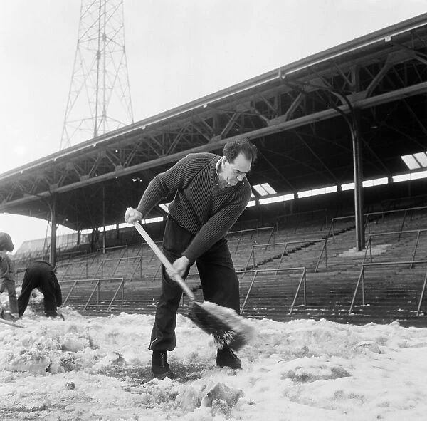 Manager Joe Harvey and players, clear snow from pitch at St James Park