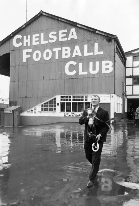 Framed Print : Manager Tommy Docherty leaving Chelsea Ground with a methuselah of champagne presented by