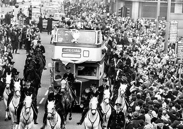 Manchester City footballers parade the FA Cup trophy to fans lining the streets of