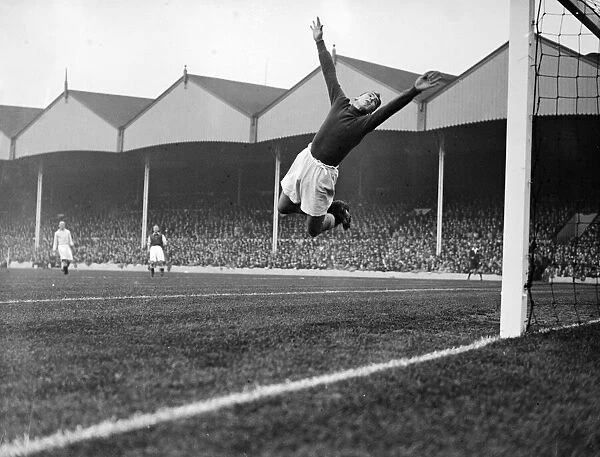 Manchester City goalkeeper Frank Swift making an athletic save in a league match against